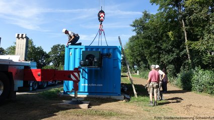 Mitarbeiter entfernen die Ketten des Schwerlastkrans vom Container (Ozonung)